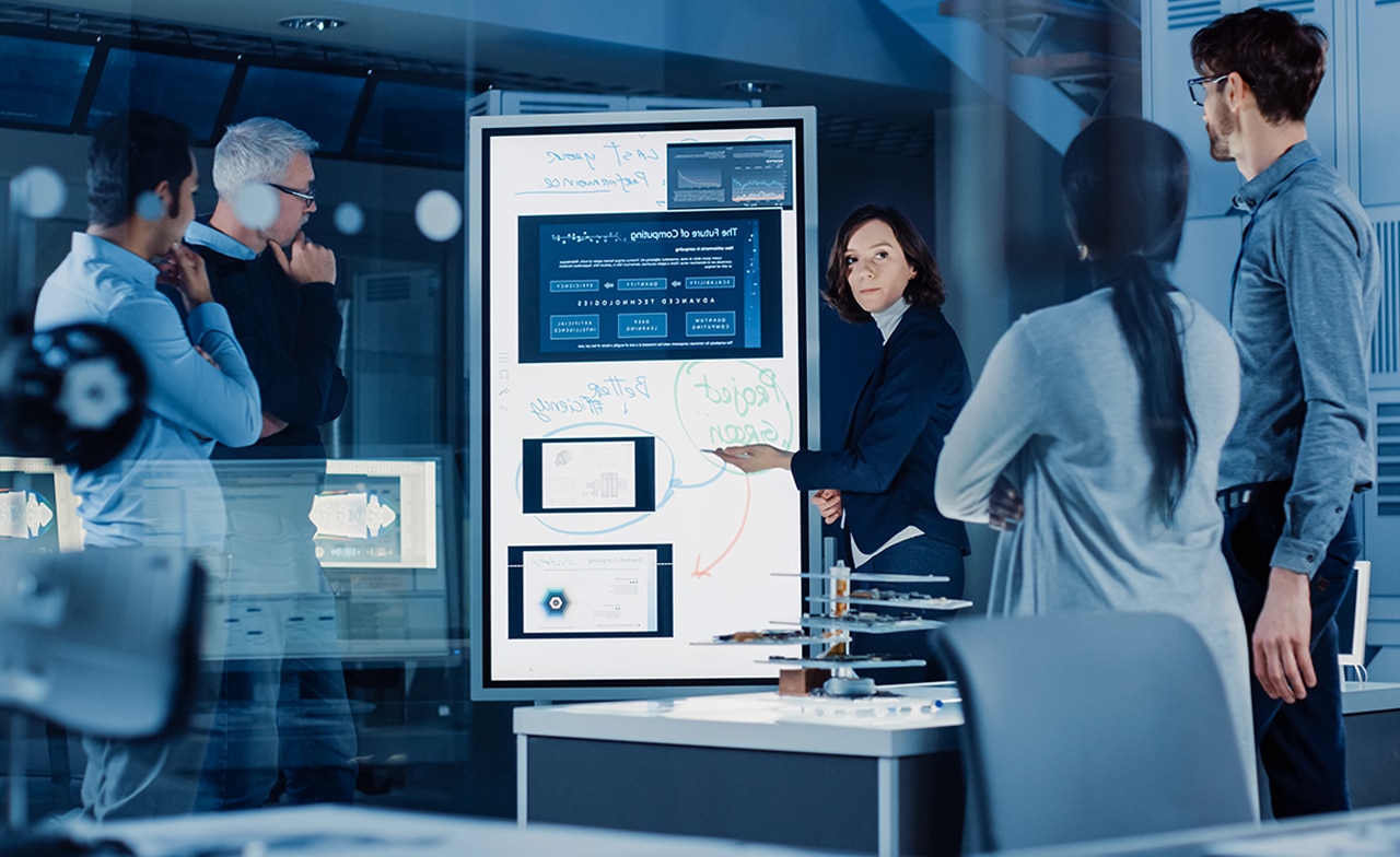 Group innovation smart screen discussion Group of professionals discuss data seen on a smart screen