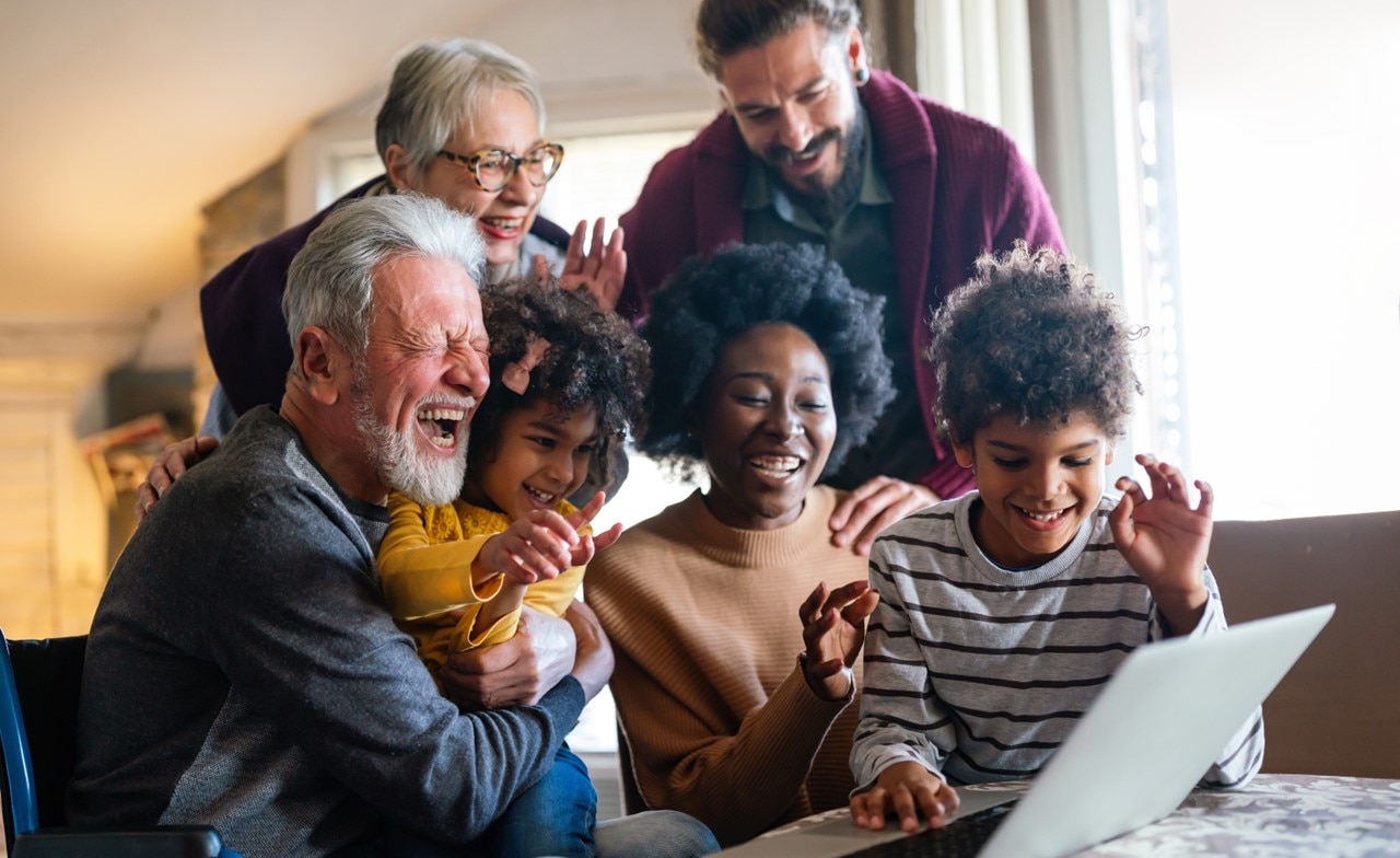 group-laughing-looking-at-computer A group of people laughing and looking at a computer