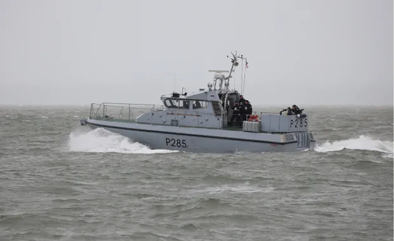 A small gray patrol boat on water A small gray patrol boat on water