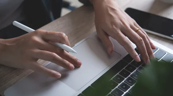Close up of woman's hands working on a laptop