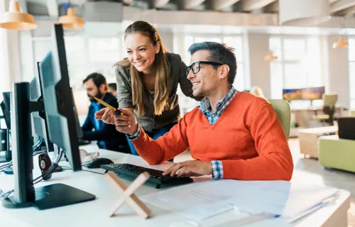two professionals looking at a computer together