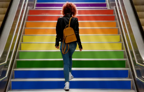 woman walking up rainbow stairs