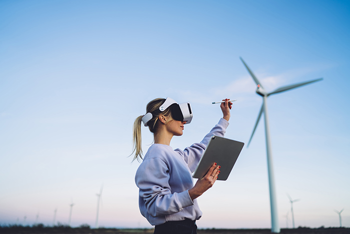 woman in vr goggles in front of a wind turbine