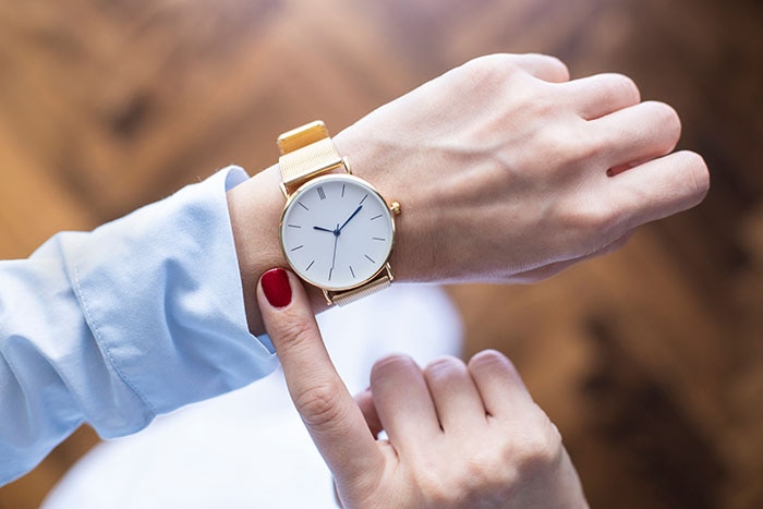 Young woman checking the time on watch