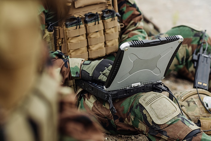 Military asset image soldier sitting and typing onto a computer