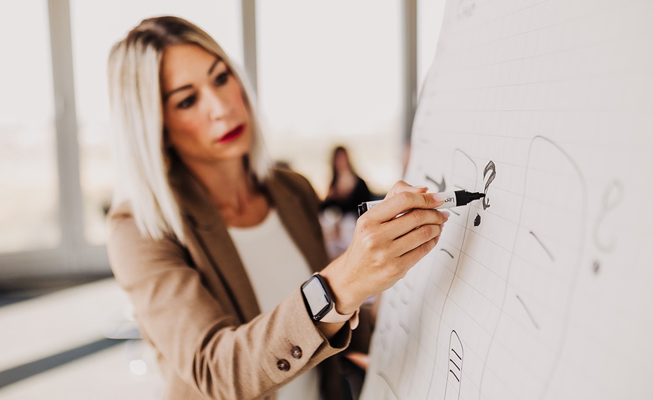 Bianca Heinemann schreibt ein Fragezeichen auf ein Flipchart