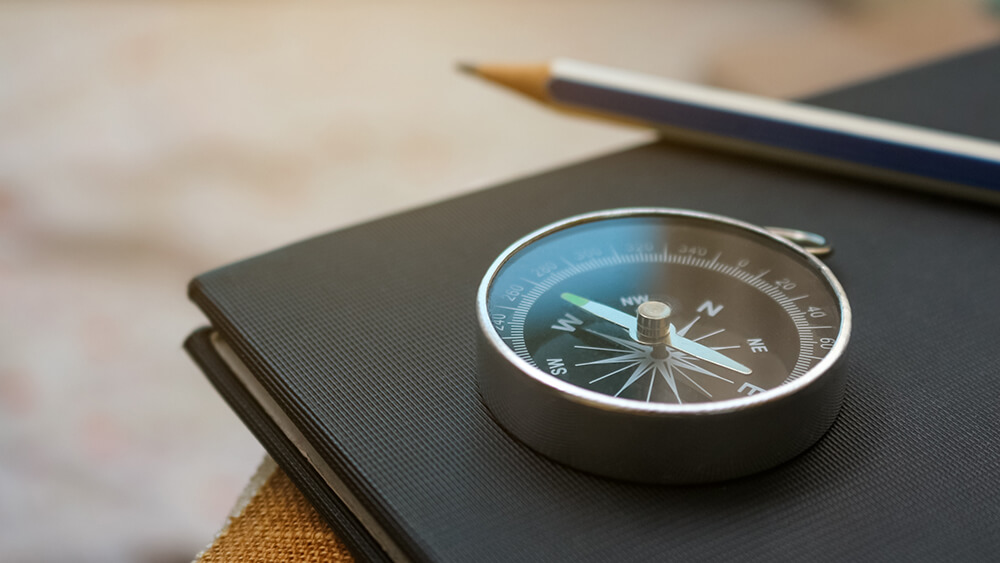 Ett kompass som ligger på en anteckninsbord