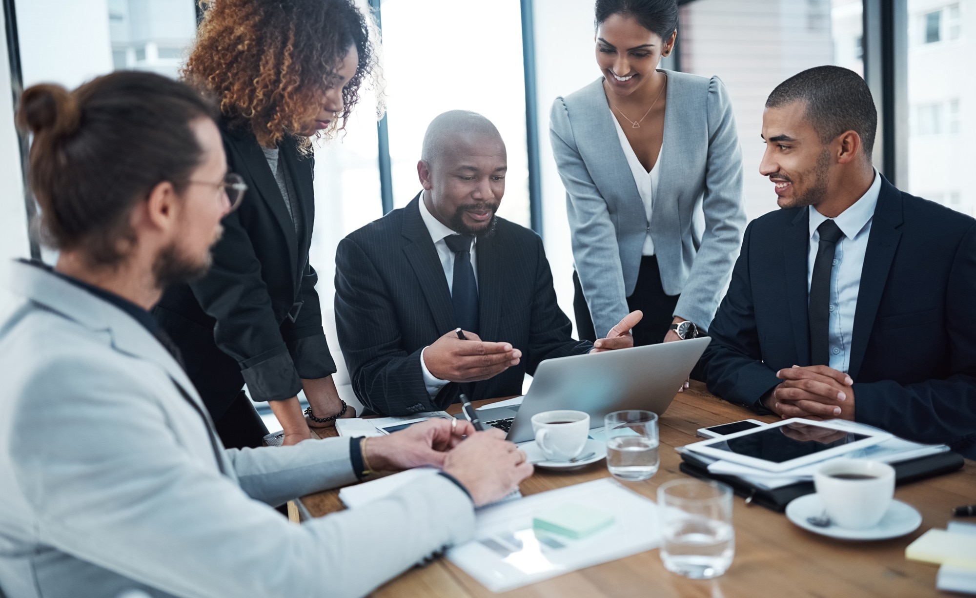 Consultants meeting around table and laptop Consultants meeting around table and laptop