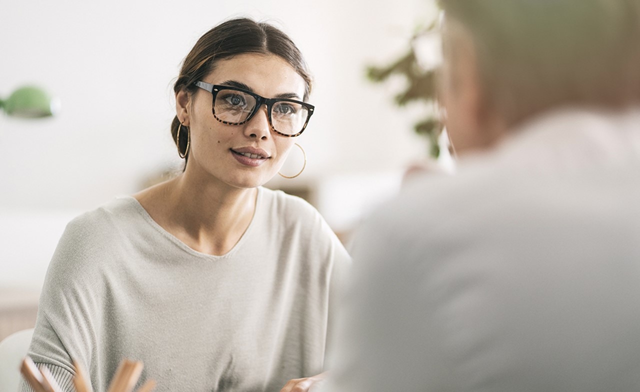 Kvinnelig konsulent i samtale med en kunde Kvinnelig konsulent i samtale med en kunde