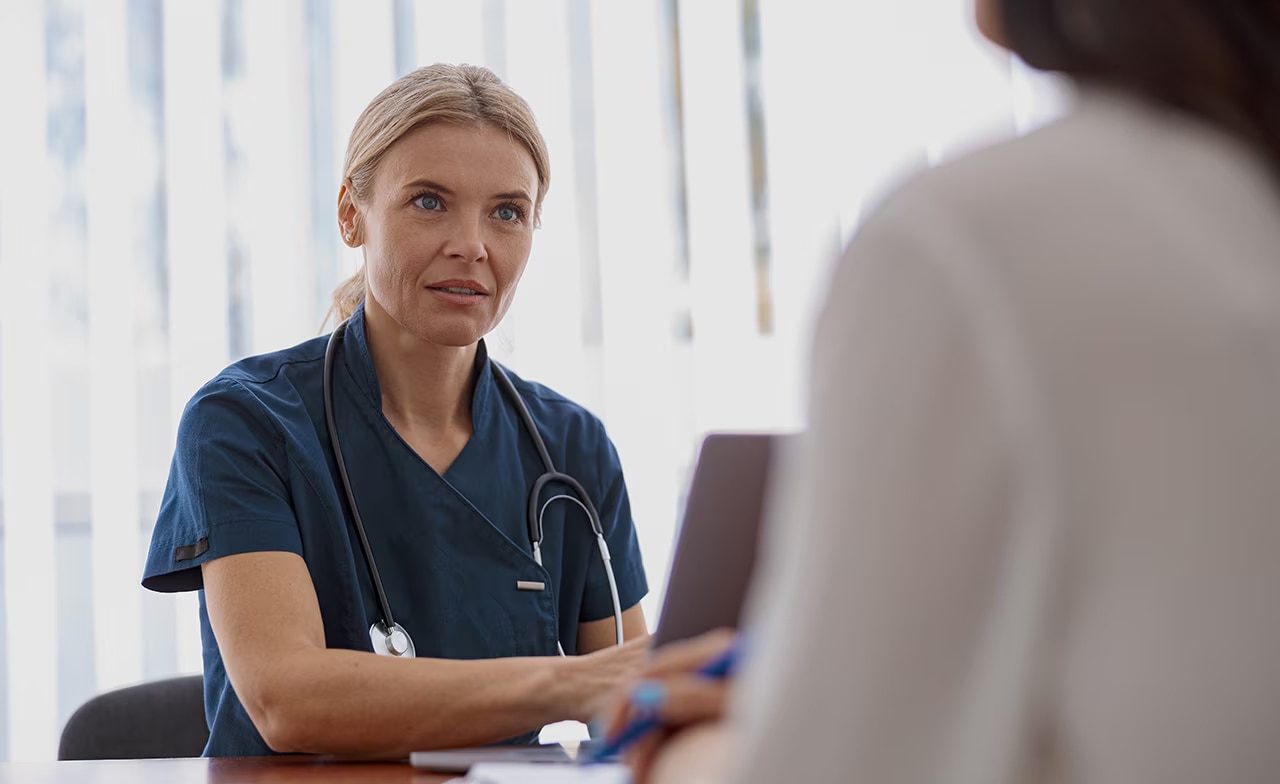 En terapeut undersöker en kvinna i sitt kontor på en modern klinik.