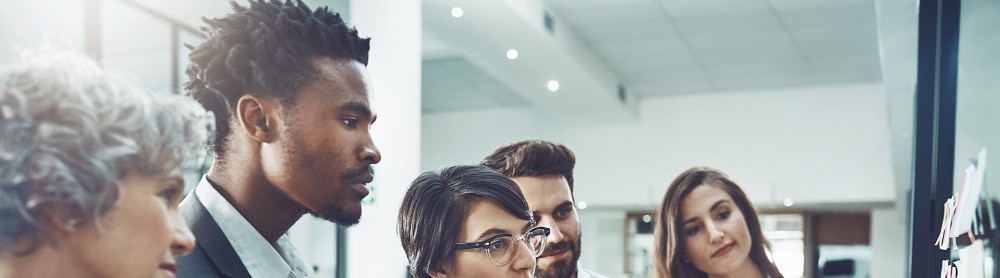 Group of people looking at whiteboard having a meeting