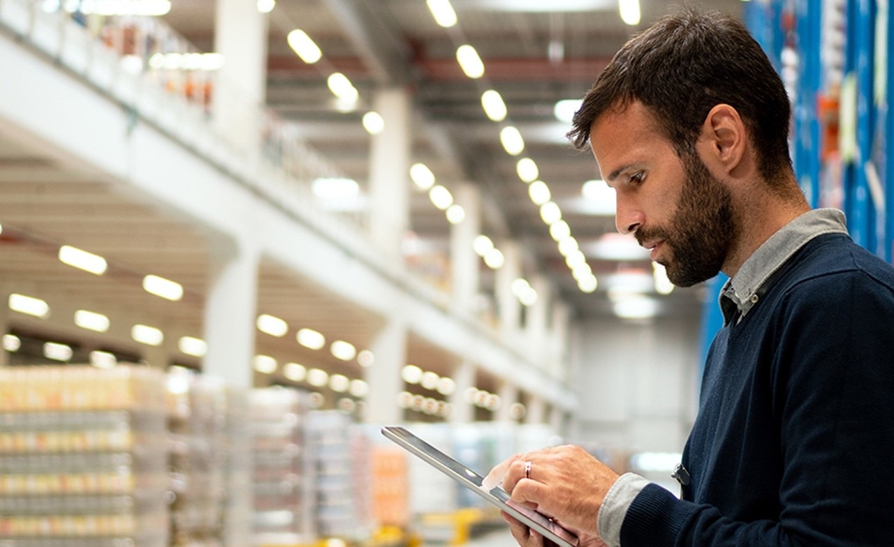 Person som holder et nettbrett på et varelager Person som holder et nettbrett på et varelager