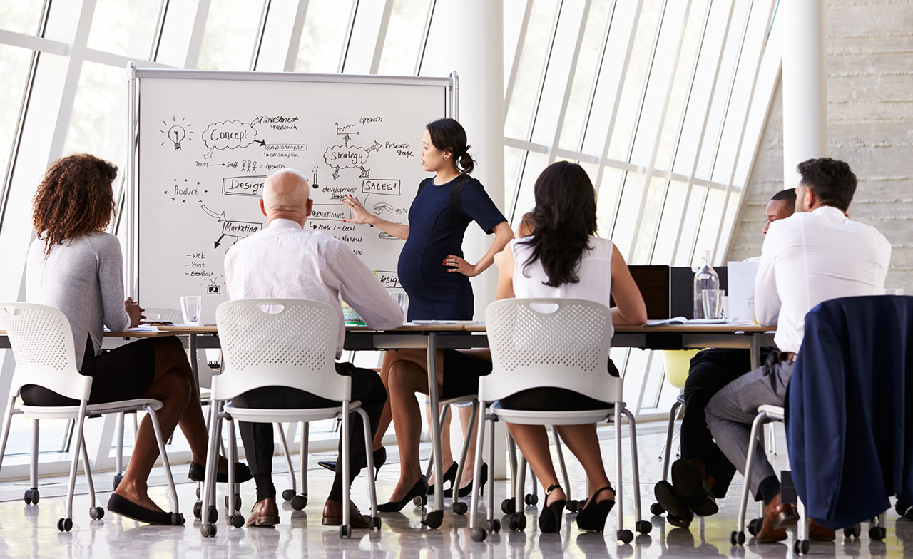 Person presenterer strategi på tavle for team – illustrerer strukturert systemutvikling og samarbeidsprosesser Person presenterer strategi på tavle for team – illustrerer strukturert systemutvikling og samarbeidsprosesser.