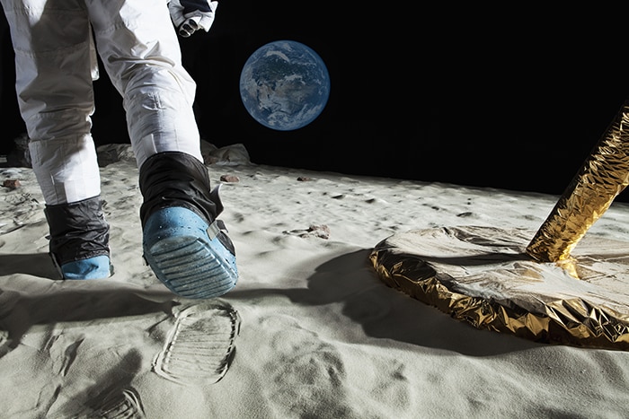 an astronaut on the moon overlooking the earth