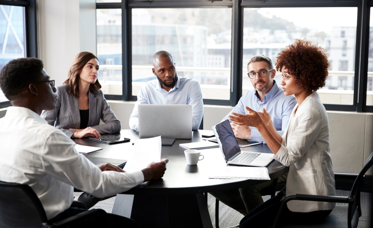 Group of professionals having a discussion around a conference table