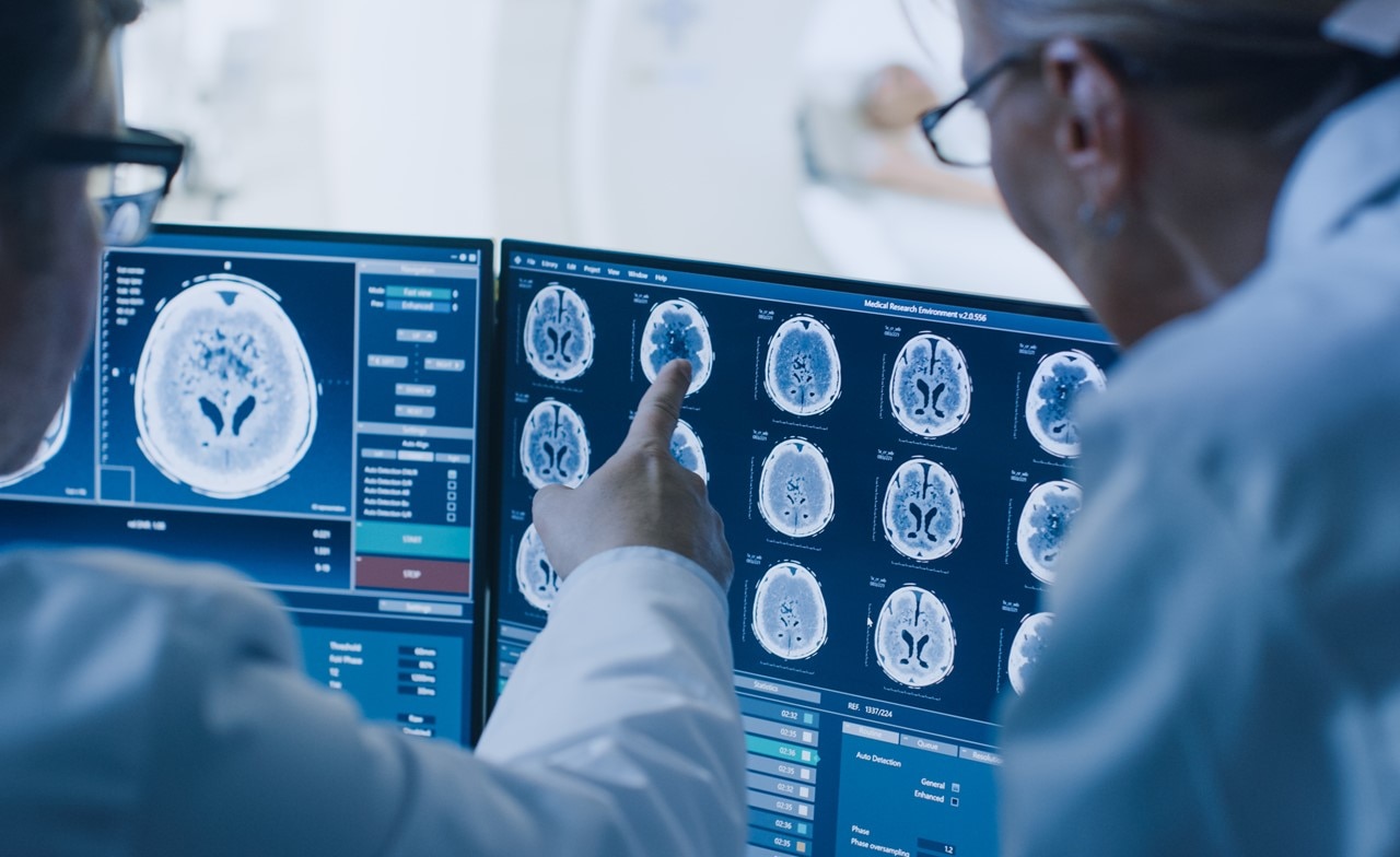 Healthcare professional reviewing brain imaging data on a screen