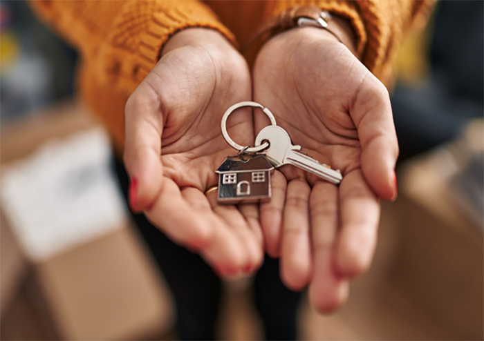 A woman holding keys to a home in her hands 