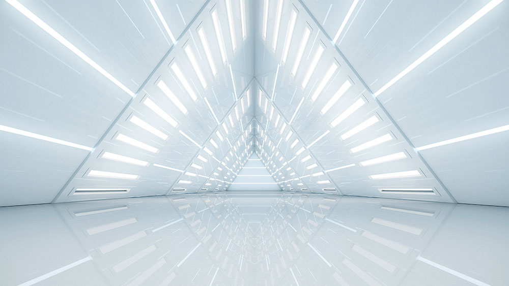 Inside of futuristic white building looking into a tunnel shaped like a triangle