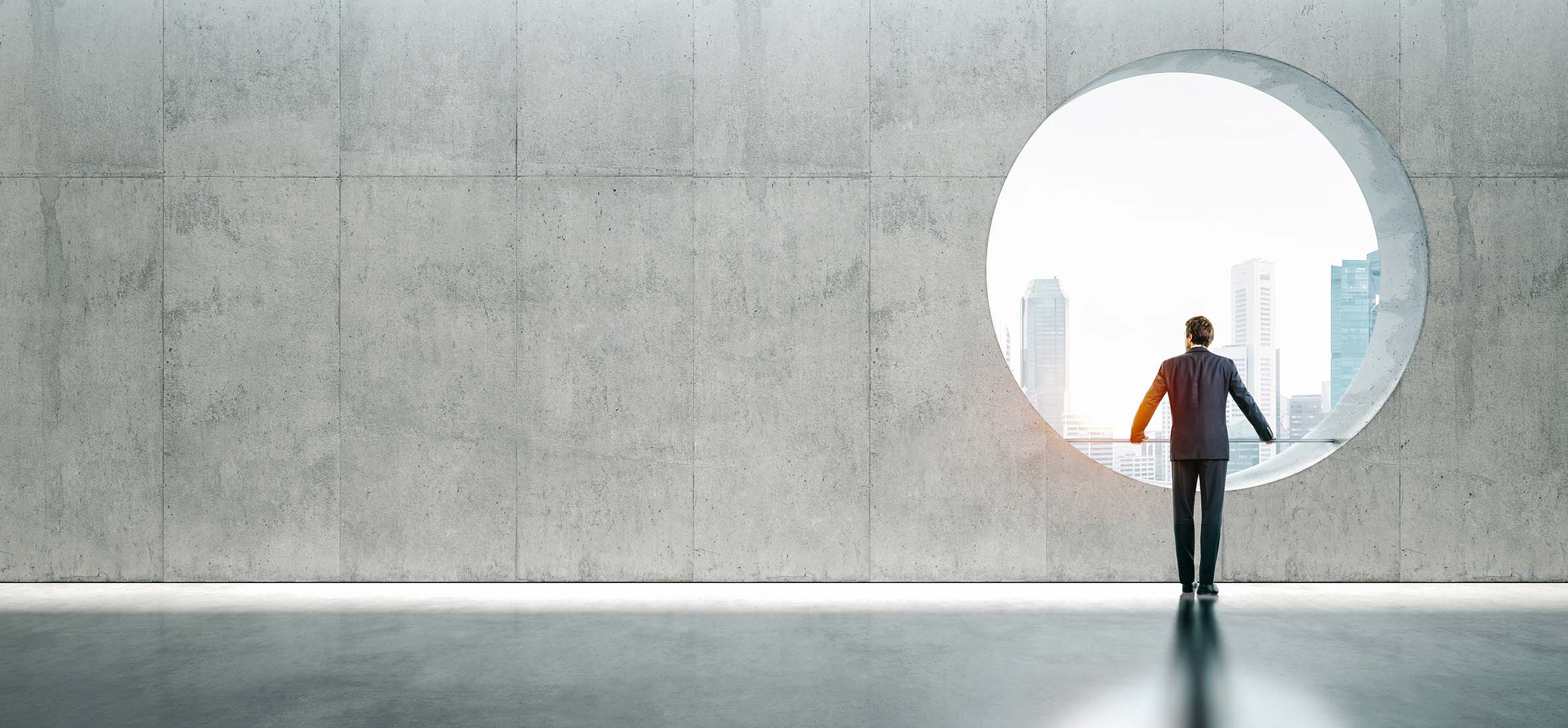 Person ser ut mot by gjennom rundt vindu – symboliserer helhetlig blikk på løsningsarkitektur Person ser ut mot by gjennom rundt vindu – symboliserer helhetlig blikk på løsningsarkitektur