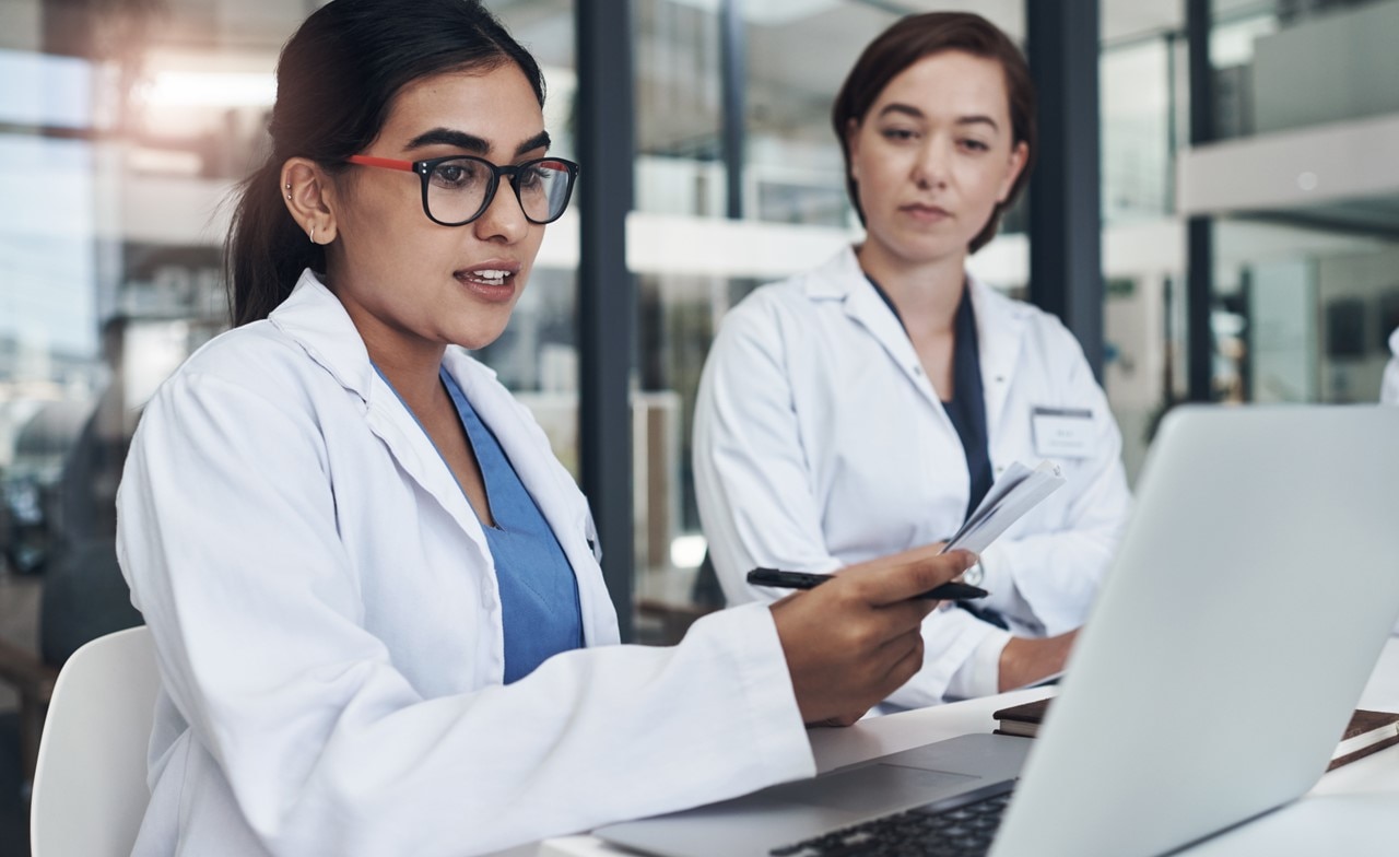 Medical professionals discussing information displayed on a laptop