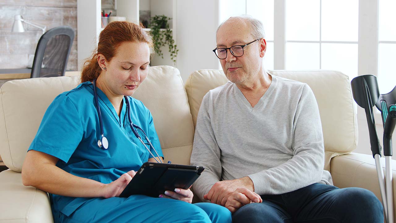 Healthcare worker shows patient data on tablet