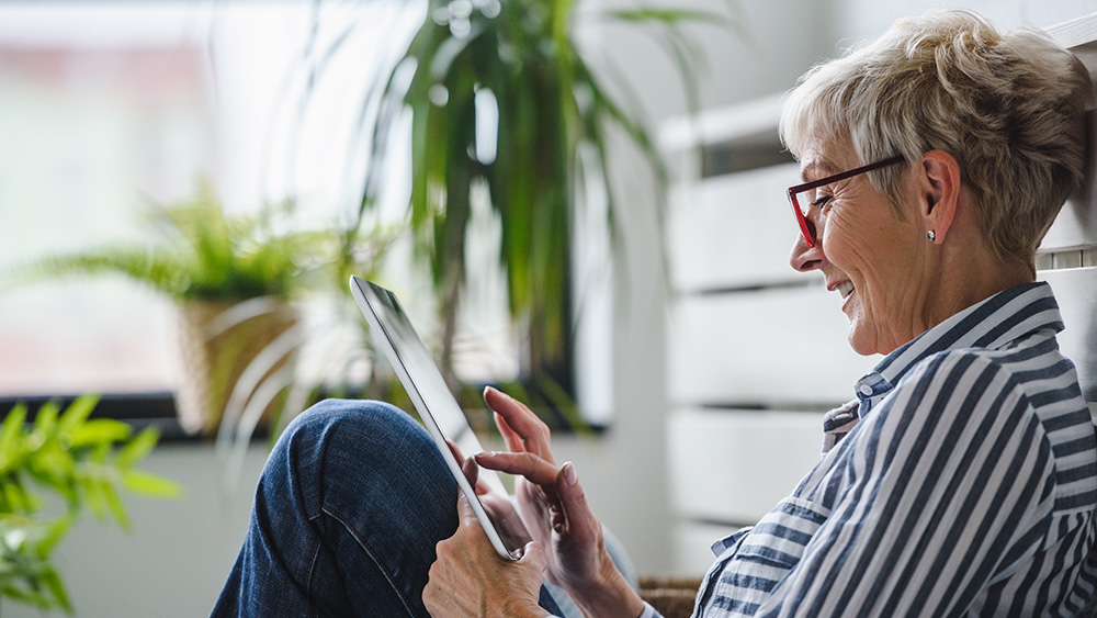 Senior woman using digital tablet at home