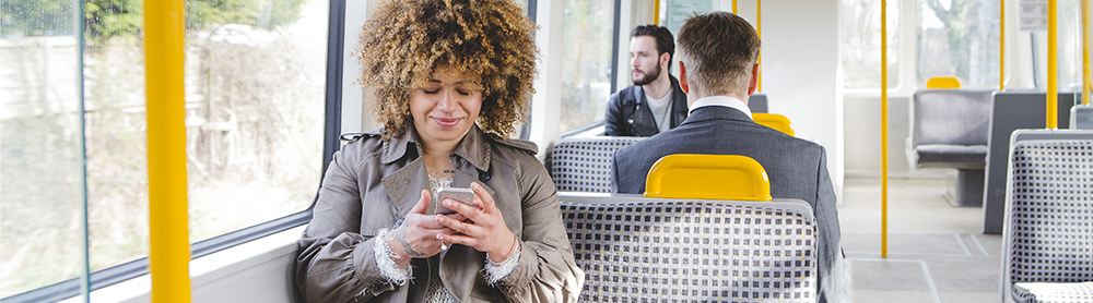 Female sitting on public transport looking at phone 