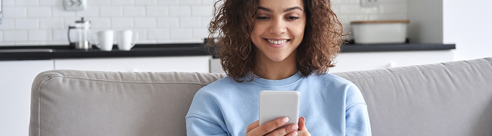 person on a sofa using an app on mobile phone person on a sofa using an app on mobile phone