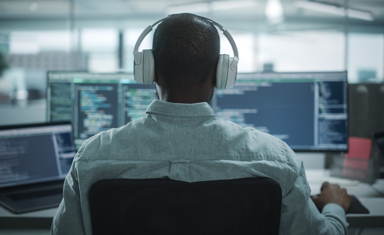 Person wearing headphones while working at a computer station