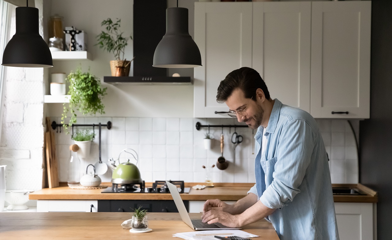 person working on laptop on kitchen counter