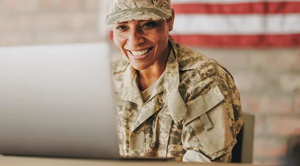 service member sitting in front of a computer 