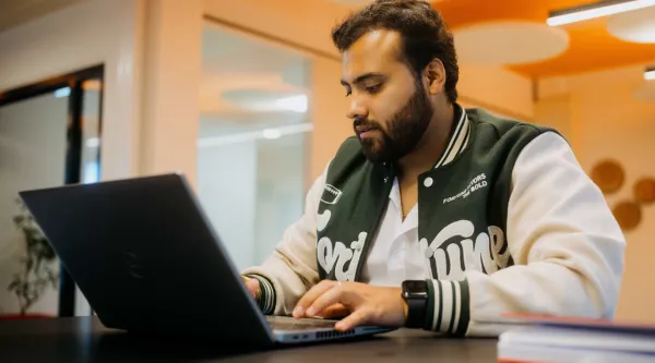 Karan Sethi sitzt vor seinem Laptop und programmiert