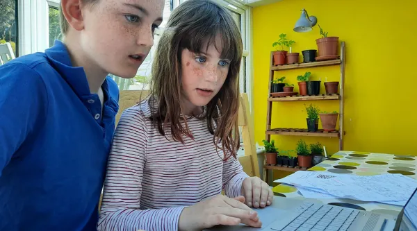 Children working on STEM activities on a laptop computer from home