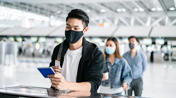 man in a mask holding a passport 