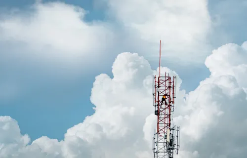 Aerial view of 5G telecommunications tower with clouds in background