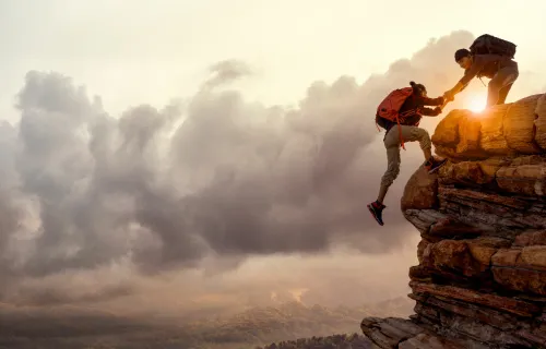 dos personas subiendo una montaña
