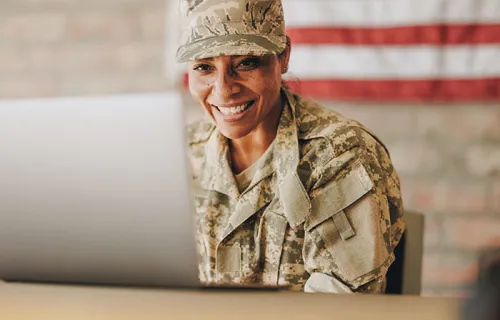 service member sitting in front of a computer 