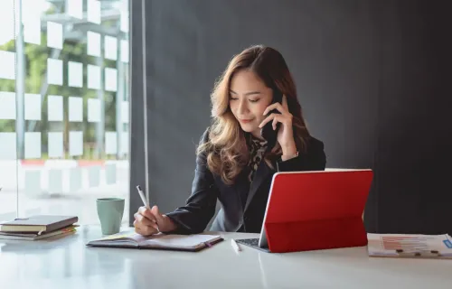 Businesswoman talking on a mobile phone at a desk