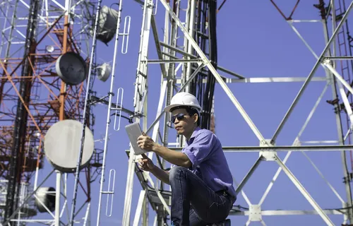 A worker uses technology on communications equipment, representing the CGICarnotsatCarnotSat …