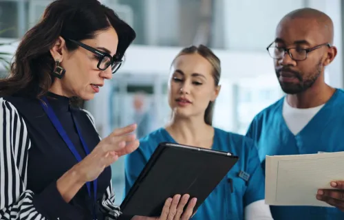 consultant discussing data on a tablet with healthcare professionals