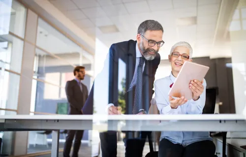 Zwei IT-Berater stehen zusammen und gucken gemeinsam in einen Laptop