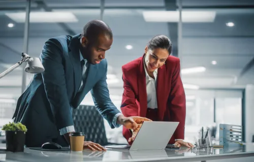 two executives pointing to laptop discussing cybersecurity and risk management