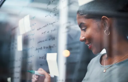 Engineer working out code on a whiteboard