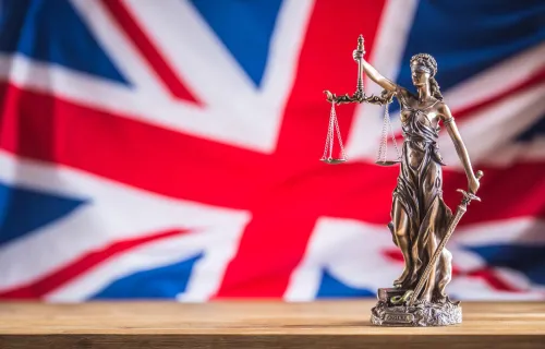 Lady Justice statue in front of Union Jack flag