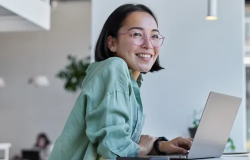 Female professional working on corporate laptop and smiling 
