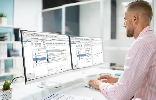 Professional working in front of two computer screens