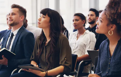 Professionals listening to a speaker at a event