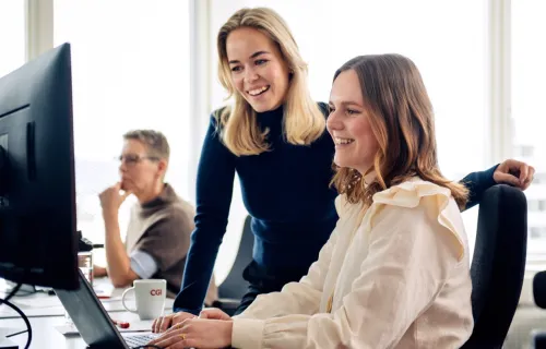 två leende CGI-konsulter som arbetar
