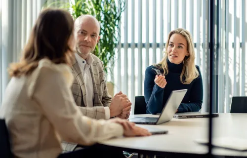 Three colleagues meeting in a conference room at the office