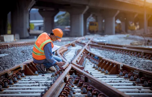 train worker inspecting tracks